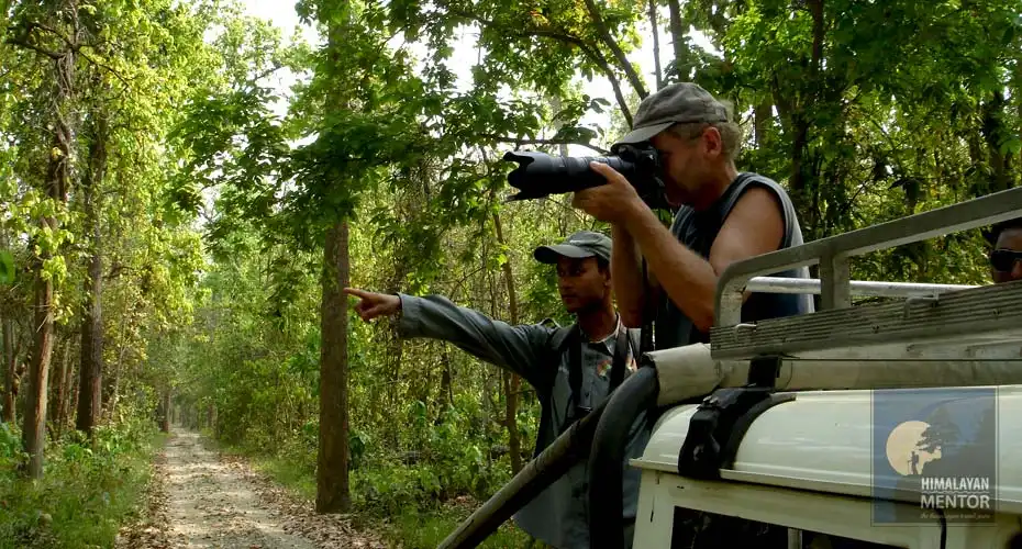 A traveler is capturing the wildlife in his camera during jeep safari in Chitwan.